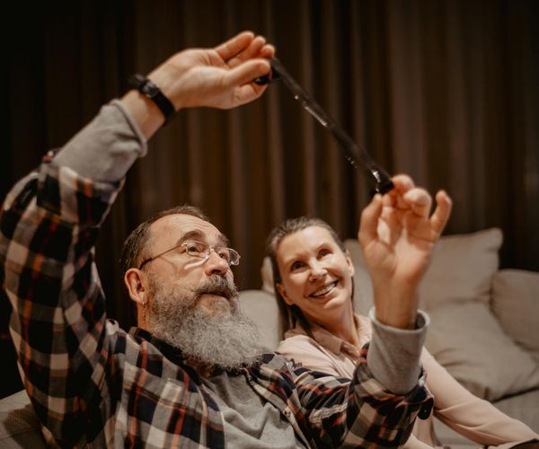 Smiling woman stretching gently on a yoga mat near a large window.